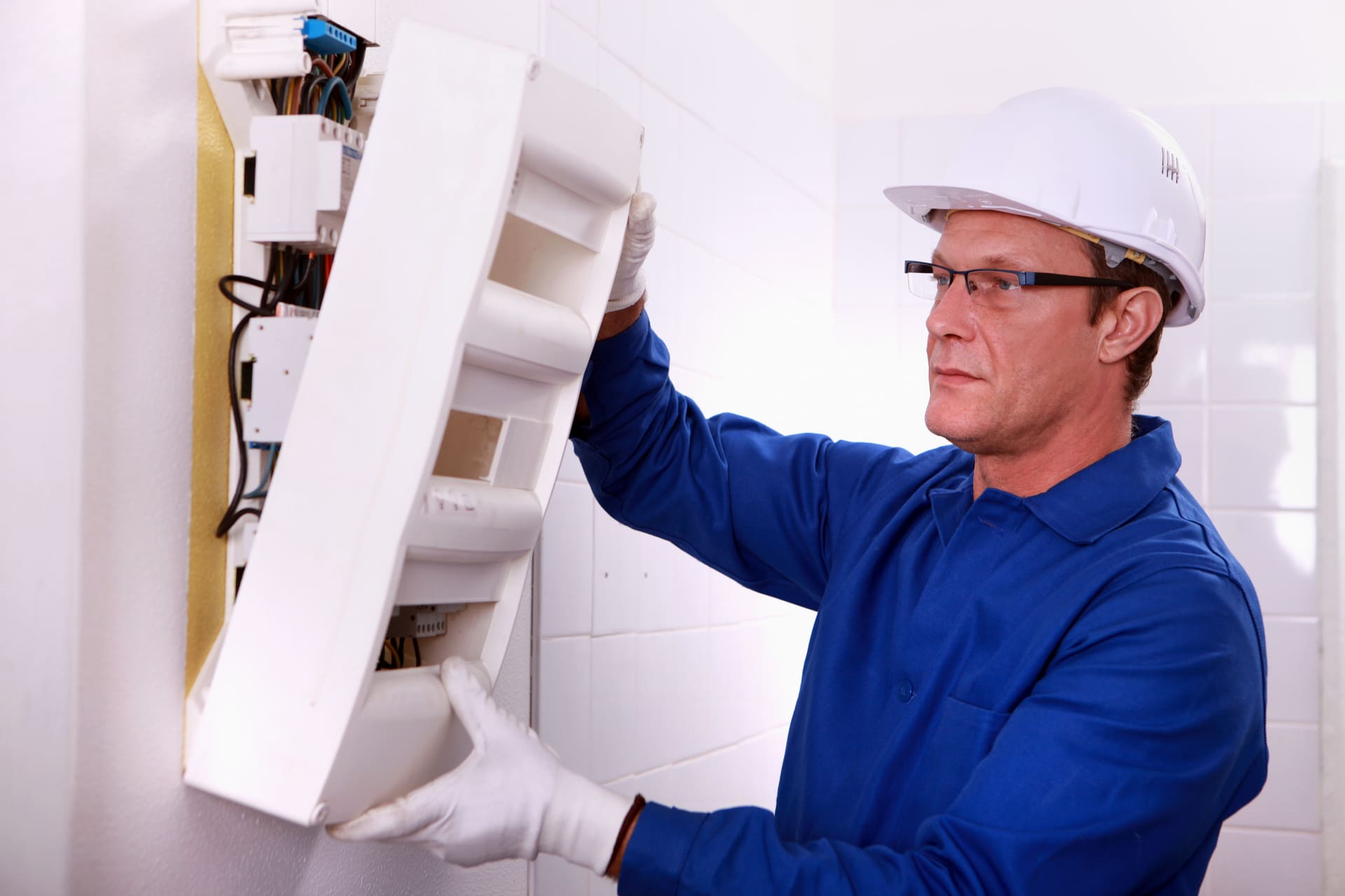 A man in a hard hat is working on a wall.